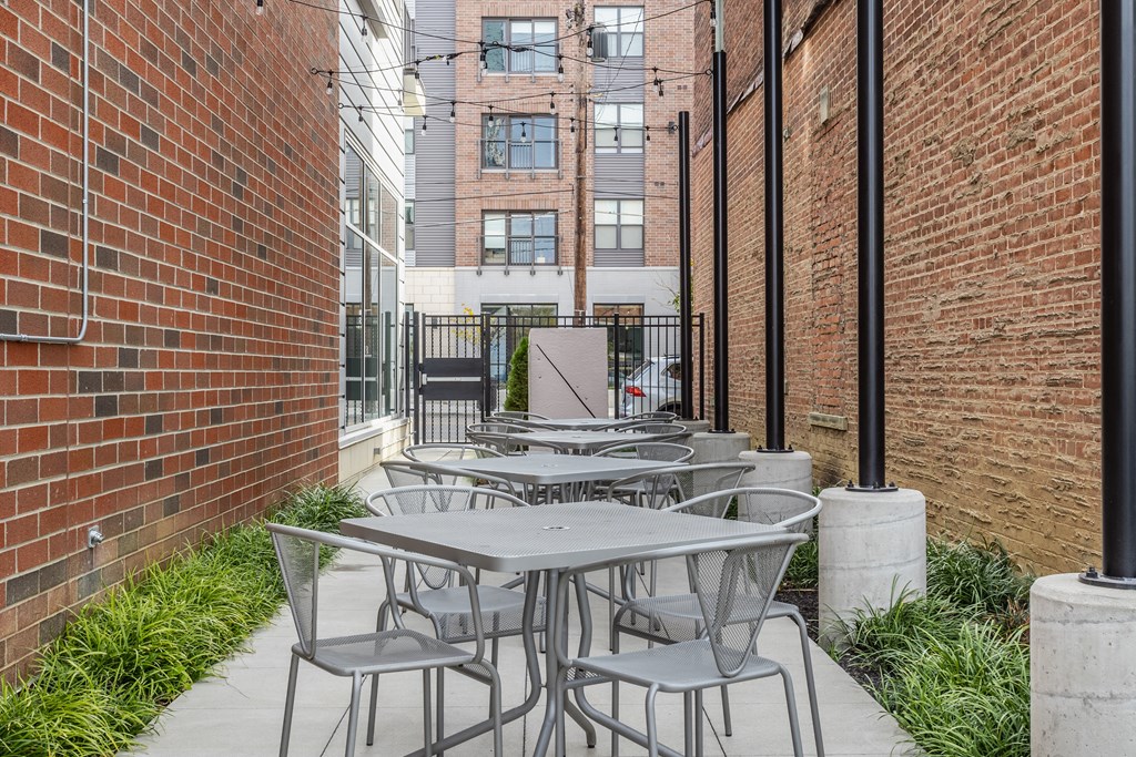 Four tables each surrounded by four chairs on an outdoor patio in Cincinnati, OH.