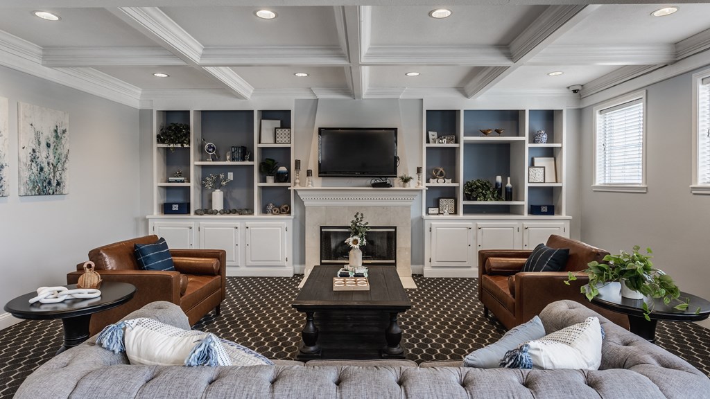 a living room with couches and a coffee table in front of a fireplace