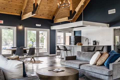 Fairway Lakes clubhouse featuring a grey couch, tables and chairs, and modern decor.