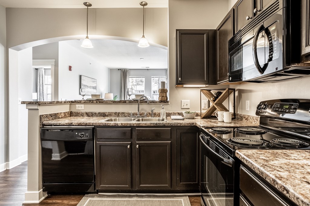 a kitchen with dark cabinets and granite countertops