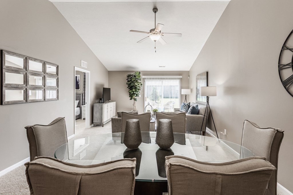 a dining room and living room with a large glass table and chairs