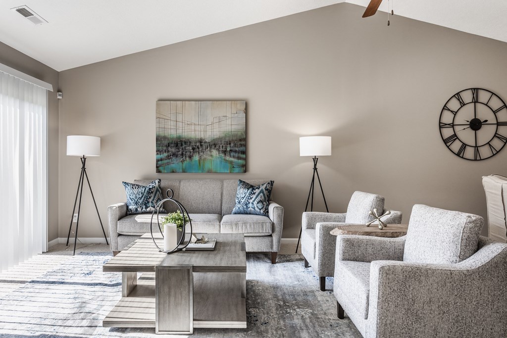 Living room at Wheaton Village featuring two chairs and a couch, two lamps, stylish decor, and carpeted floors.