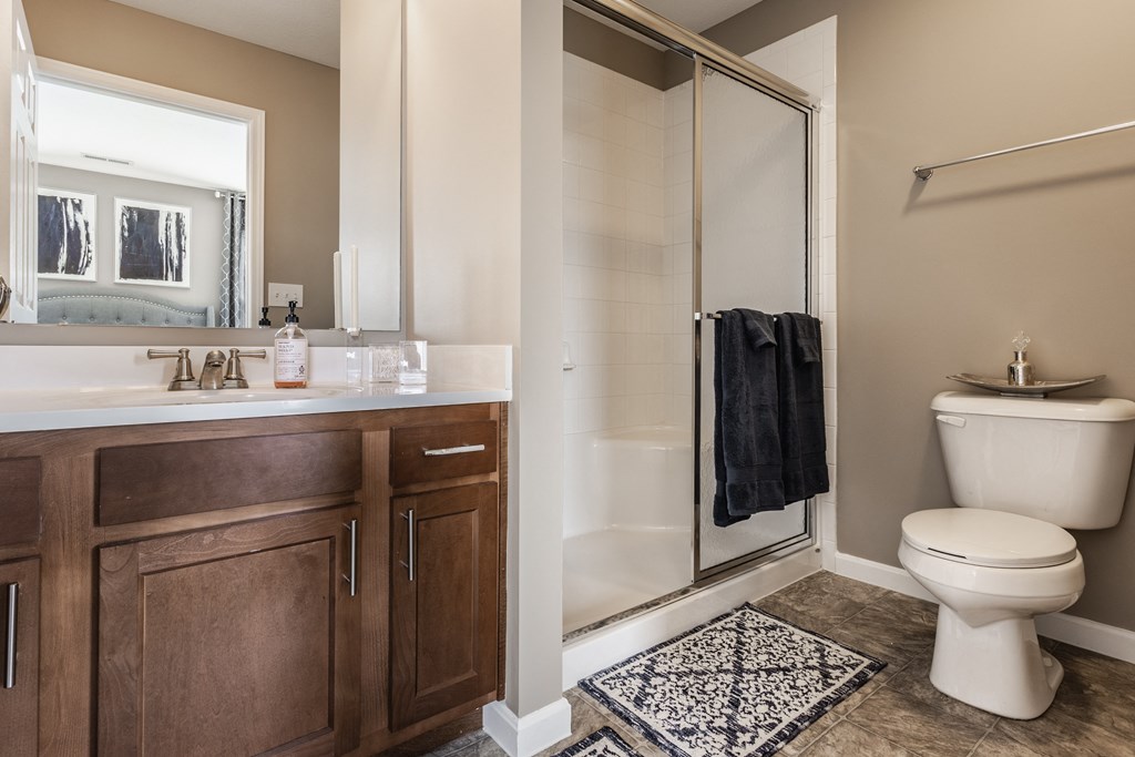 A furnished bathroom with a walk-in shower and a towel at Wheaton Village.
