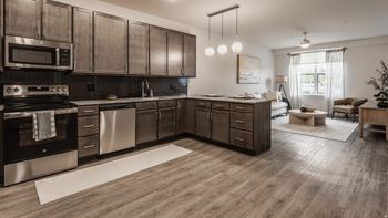 A modern kitchen with dark wood cabinets and stainless steel appliances.