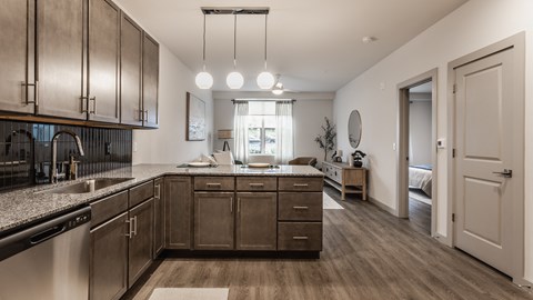A modern kitchen with dark wood cabinets and a stainless steel sink.