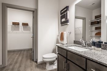 A bathroom with a toilet, sink, and a mirror.