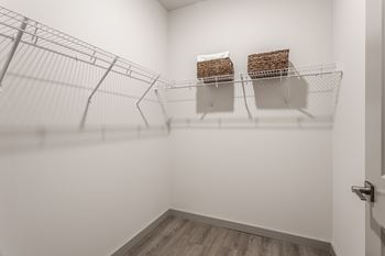 A white room with a wire shelving unit and two baskets on the shelf.