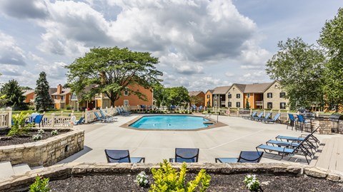 Fairway Lakes swimming pool surrounded by trees and lounge chairs,