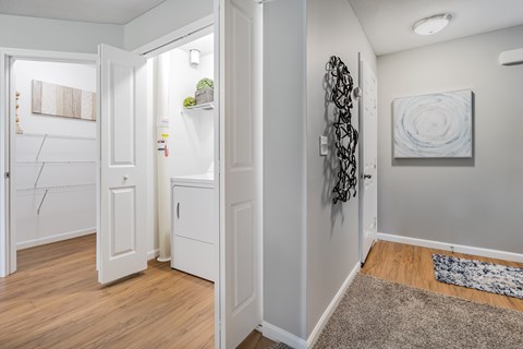 A white door is open to a hallway with a rug on the floor.