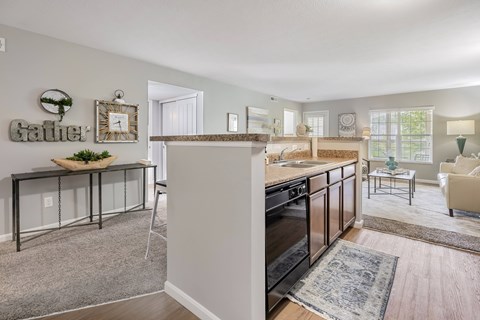 A kitchen with a black oven and a dining table with chairs.