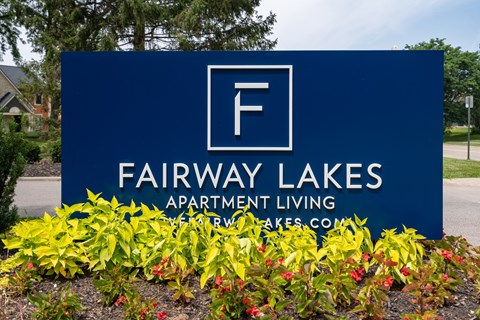A blue sign for Fairway Lakes Apartment Living with a white letter F in a white square.