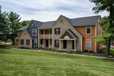 A house with a grey roof and a brown house in the background.
