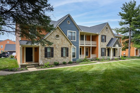 A house with a blue roof and a stone wall.