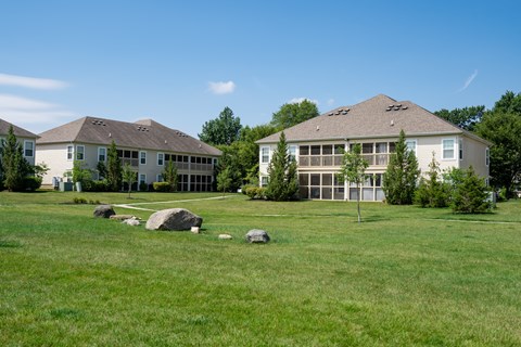 Two houses with a green lawn in front.