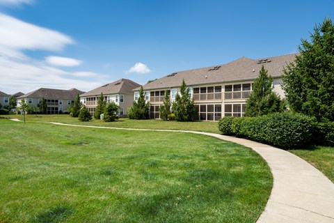 A grassy area in front of a building with a walkway.