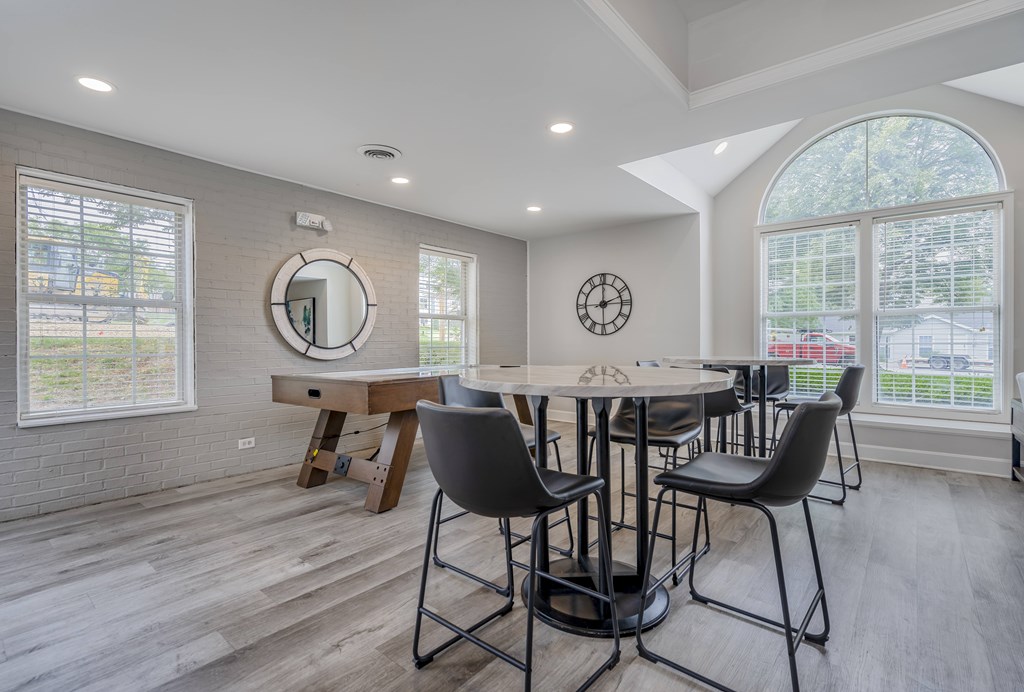 A dining room with a round table and chairs.