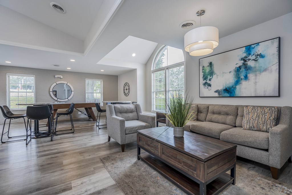 A modern living room with a large painting on the wall.