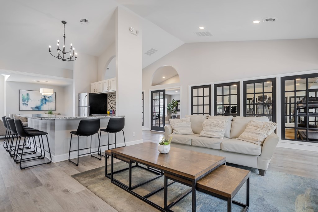 A modern living room with a bar area and a large window.