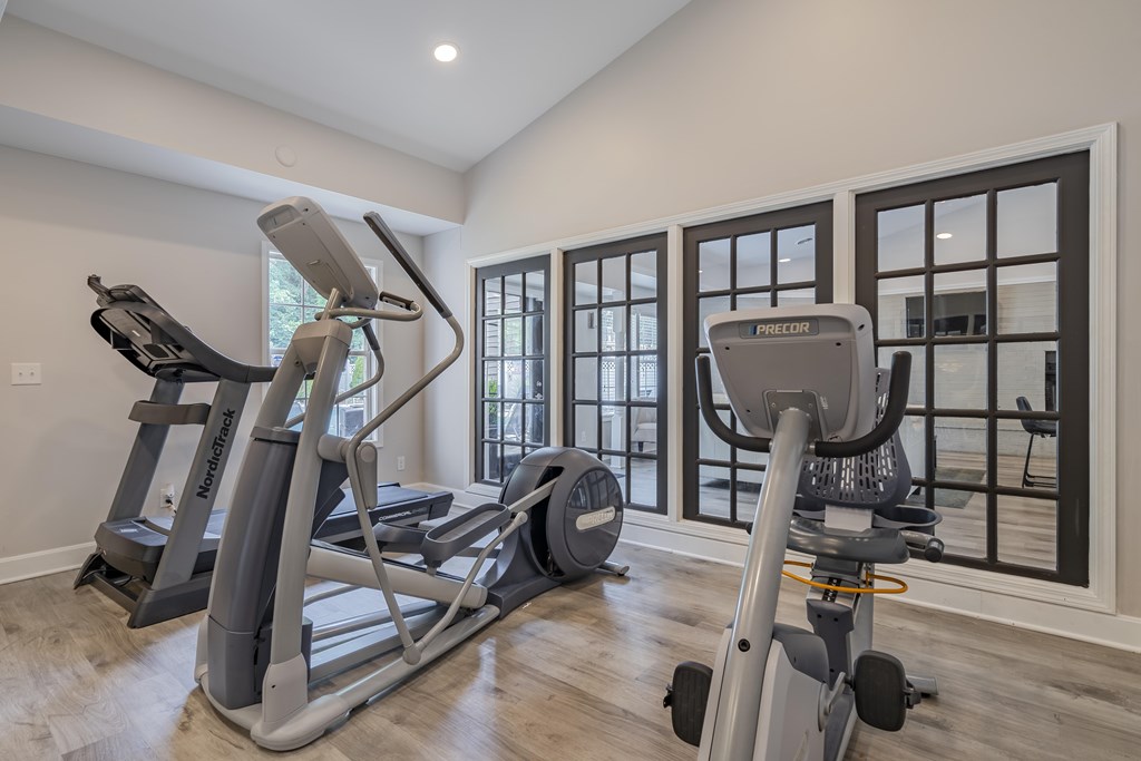 A home gym with a treadmill, elliptical trainer and a stationary bike.