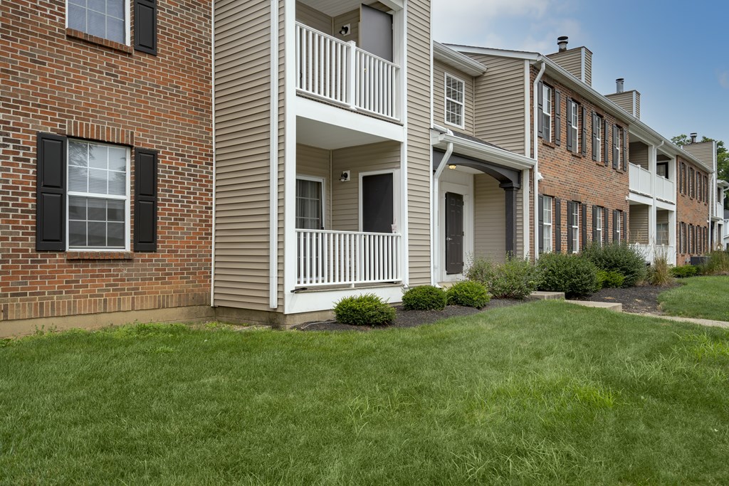 A row of townhouses with a green lawn in front.