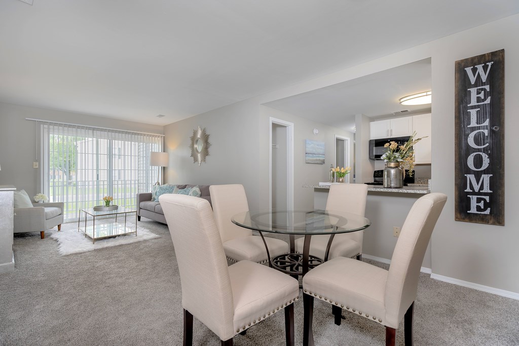 A dining room with a glass table and chairs.