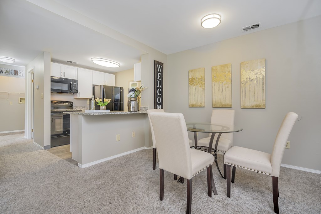 A dining room with a glass table and chairs.