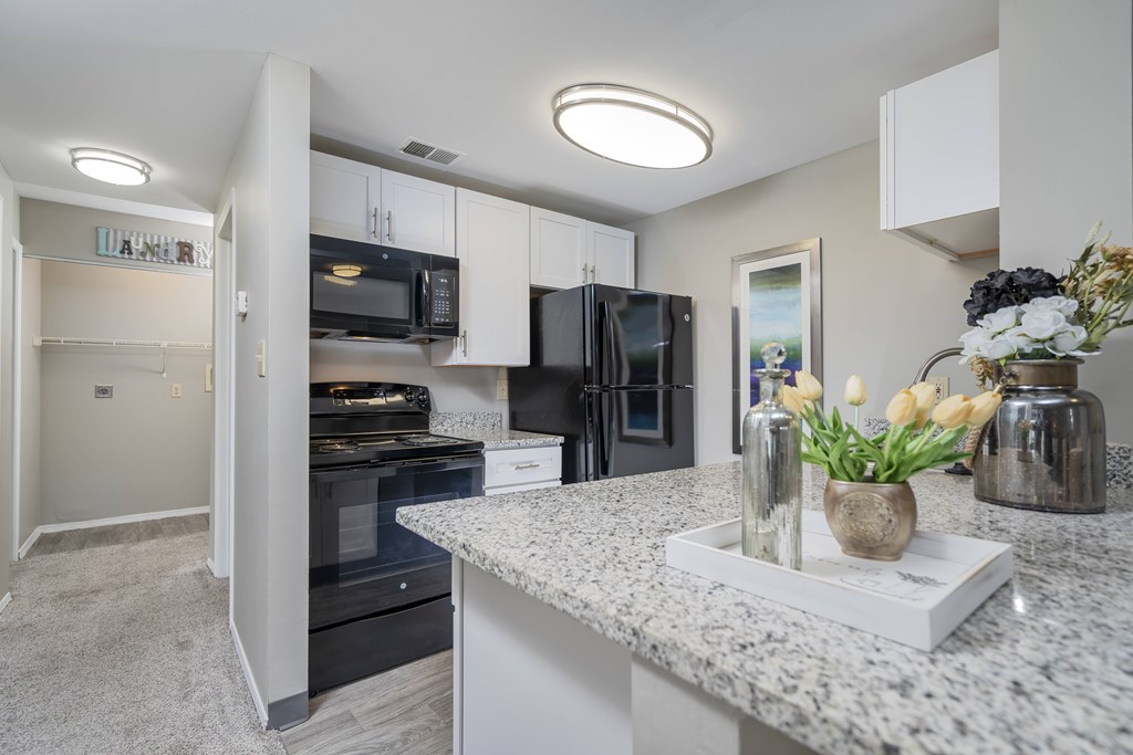 A kitchen with granite countertops and stainless steel appliances.