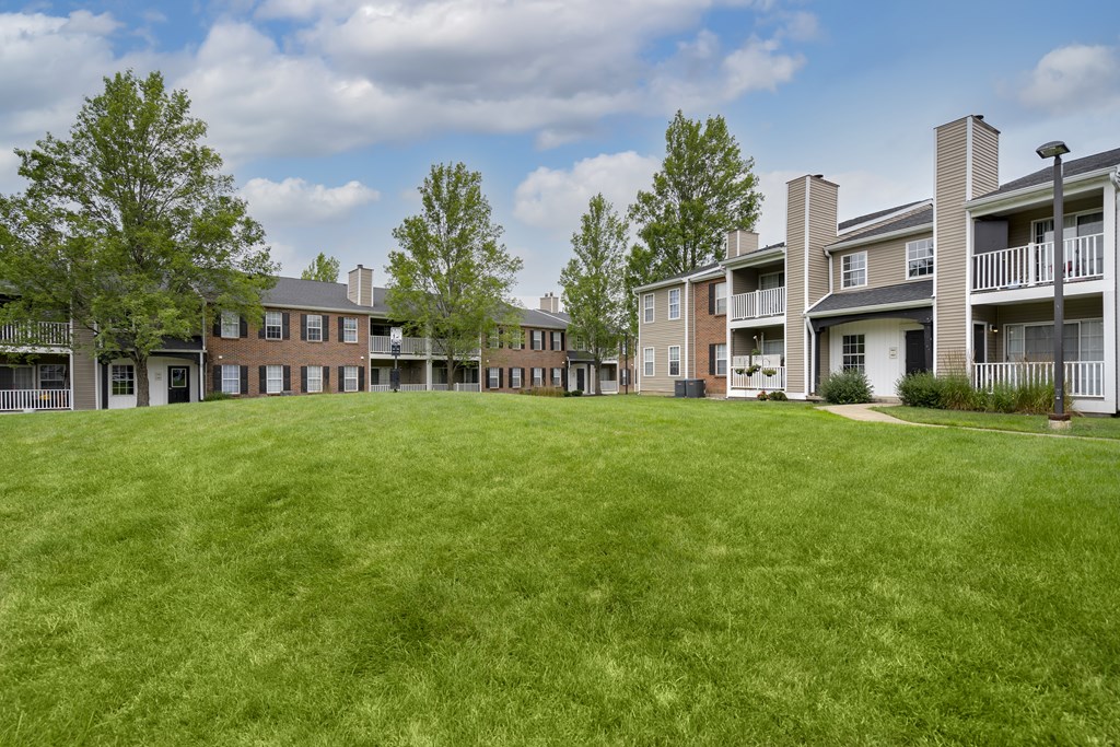 A grassy area in front of apartment buildings.