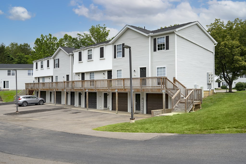 A white building with a car parked in front.