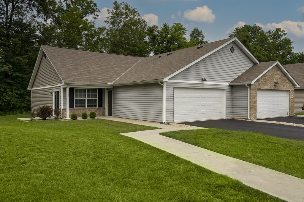 A house with a grey roof and two garages.