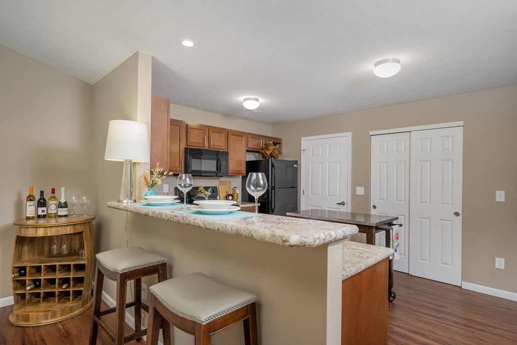 A kitchen with a bar area and a wine rack.