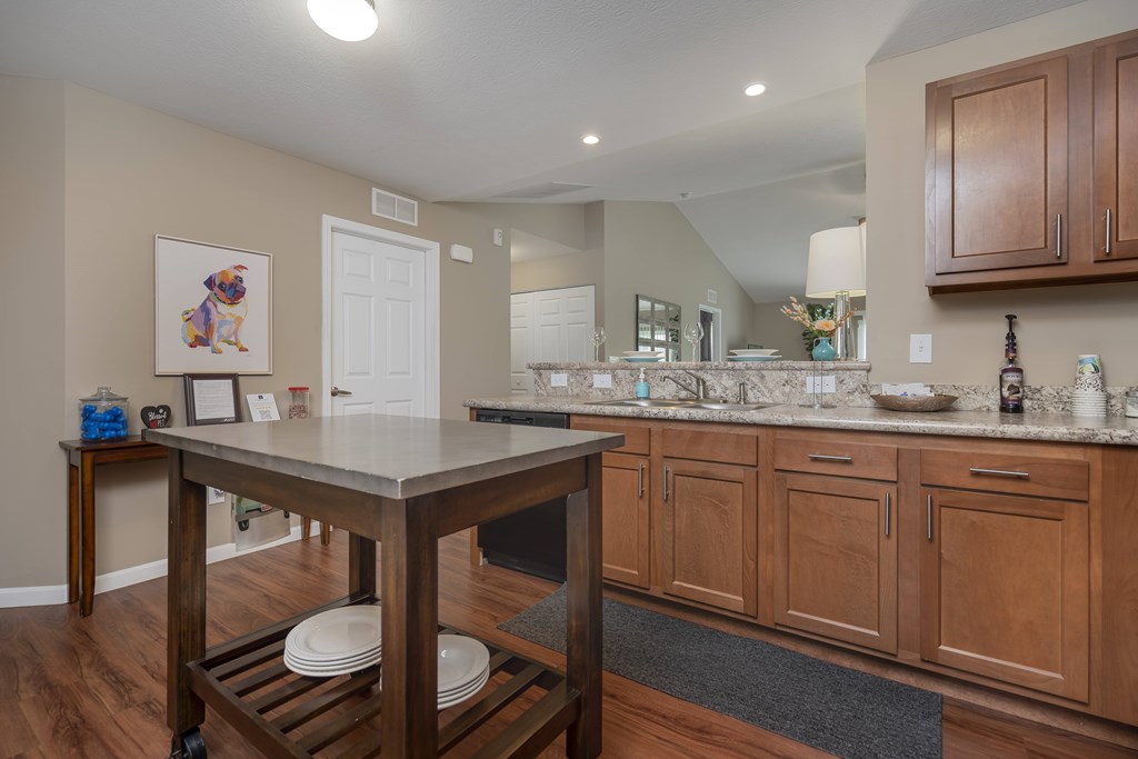 A kitchen with wooden cabinets and a white island.