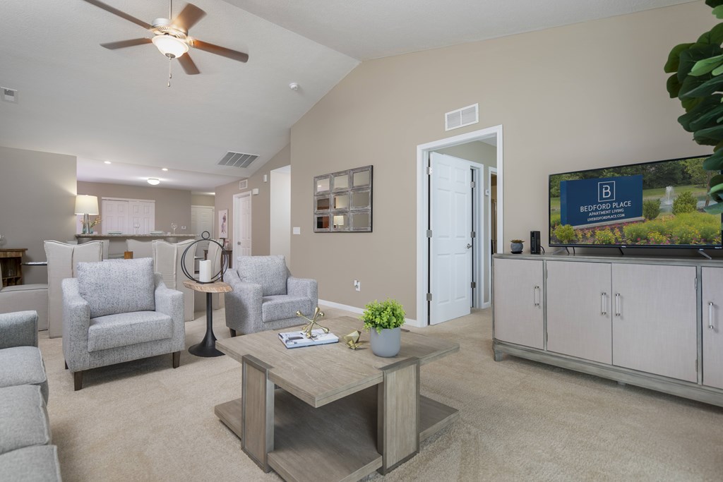 A living room with a grey sofa set, a coffee table, and a ceiling fan.