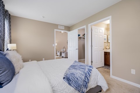 A bedroom with a bed and a nightstand with a lamp.