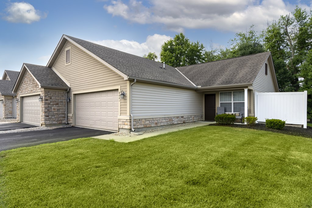 A house with a grey roof and a white fence.