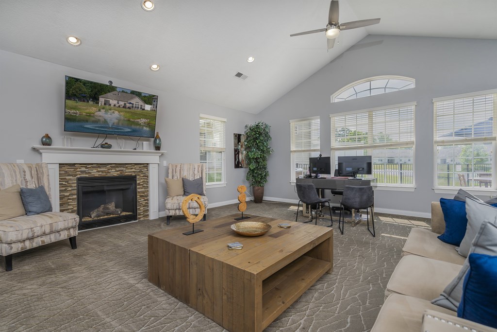 A living room with a fireplace and a television on the wall.