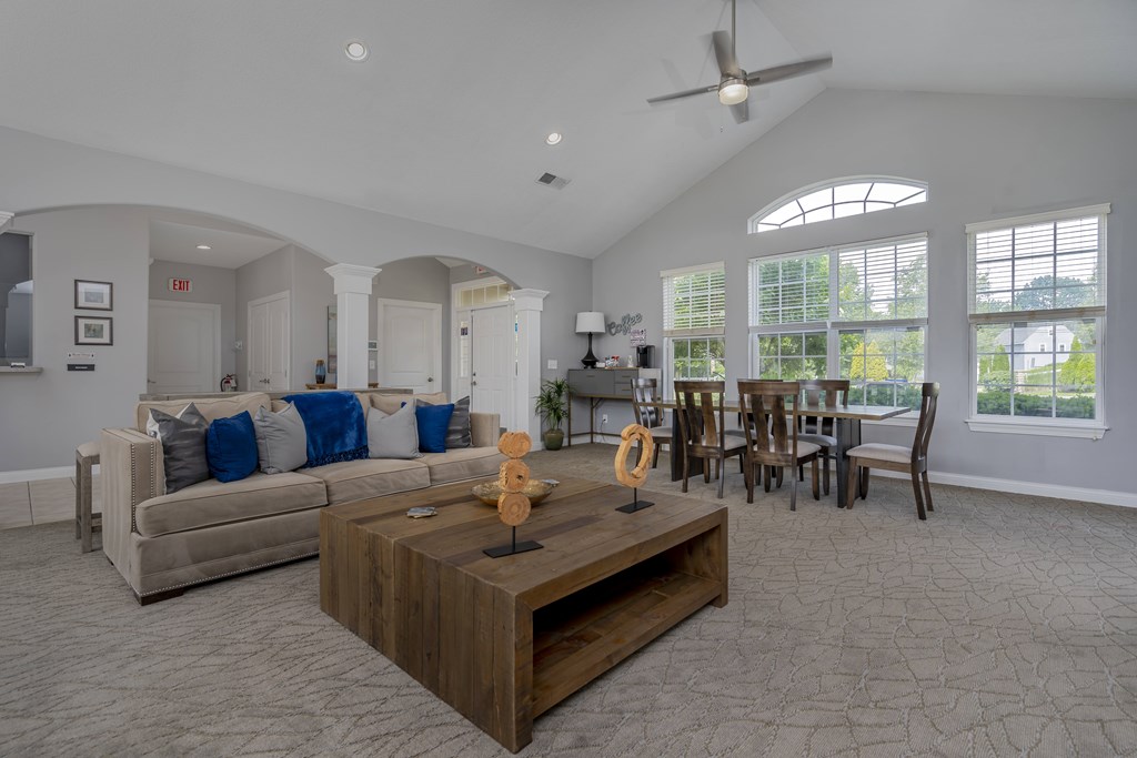 A living room with a couch, coffee table, and chairs.