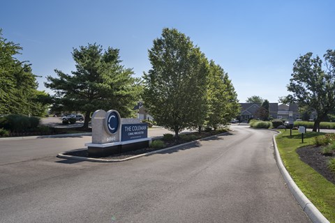 The entrance to The Colonial with a sign and trees.