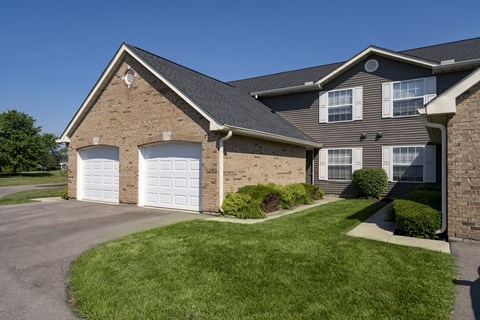 A house with a grey roof and a white garage door.