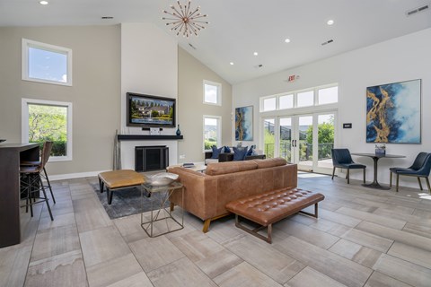A living room with a brown couch and a fireplace.