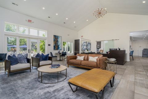 A living room with a brown leather sofa and a round coffee table.