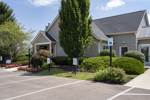 A parking lot in front of a building with a sign on it.