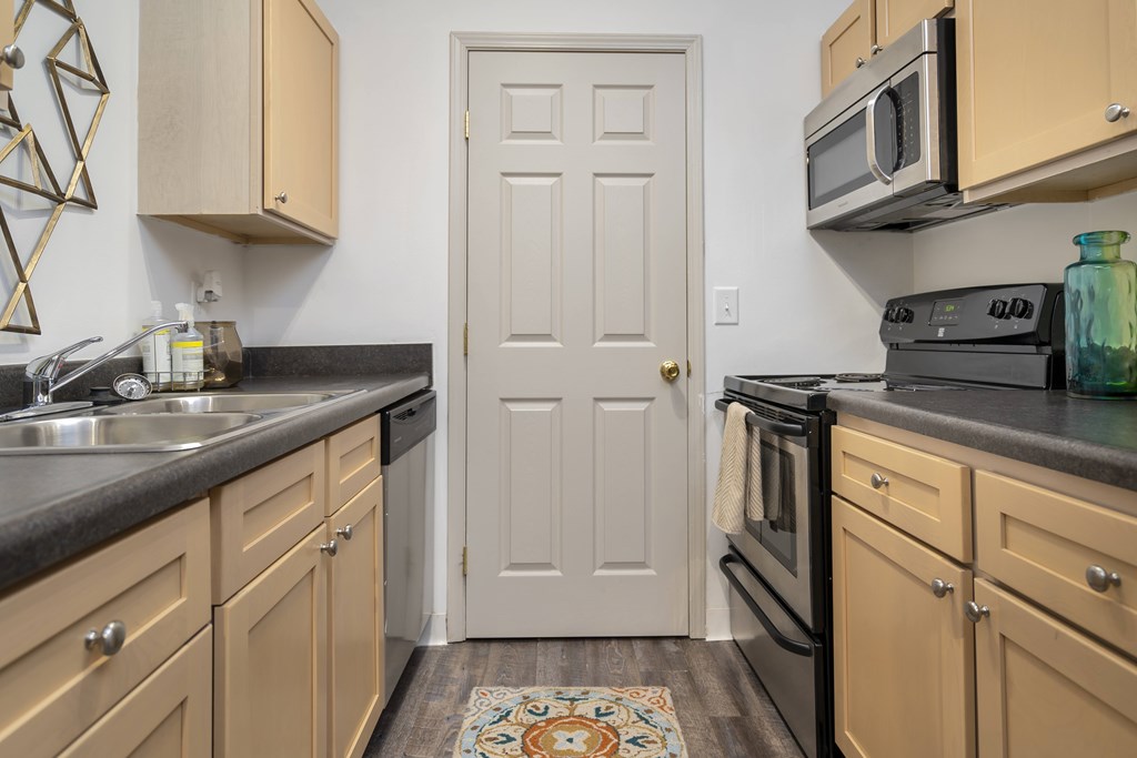 A kitchen with a white door in the middle of the room.