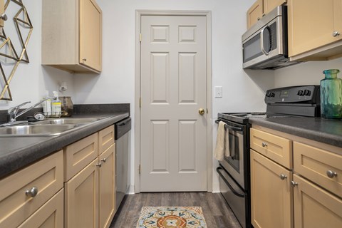 A kitchen with a white door in the middle of the room.