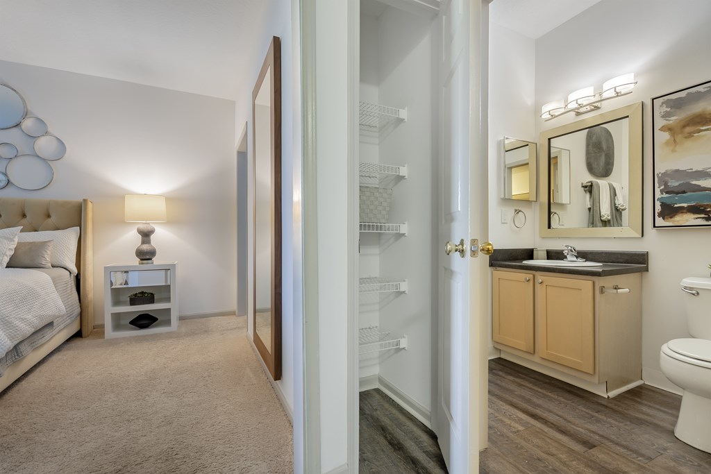 A bathroom with a toilet, sink, and mirror.
