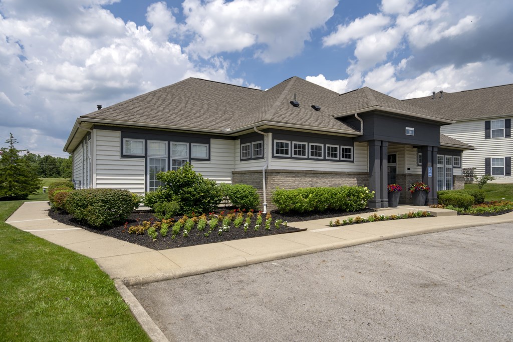 A building with a grey roof and a grey wall with a black door.