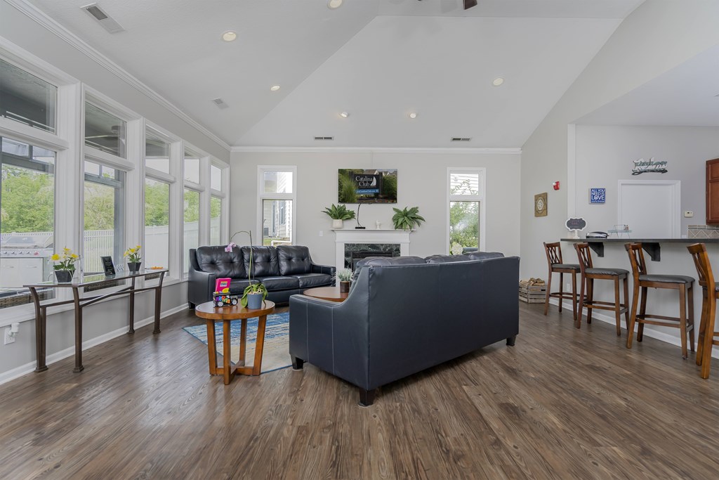 A living room with a grey couch and wooden floors.