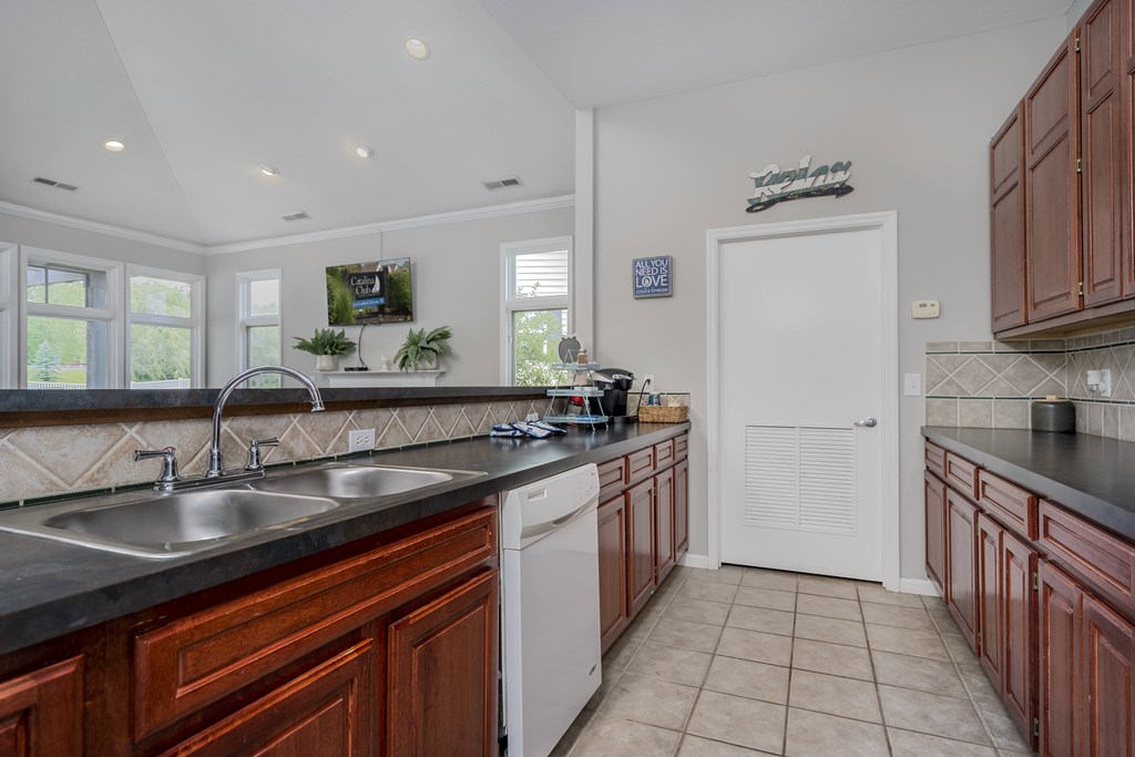 A kitchen with brown cabinets and a white door.