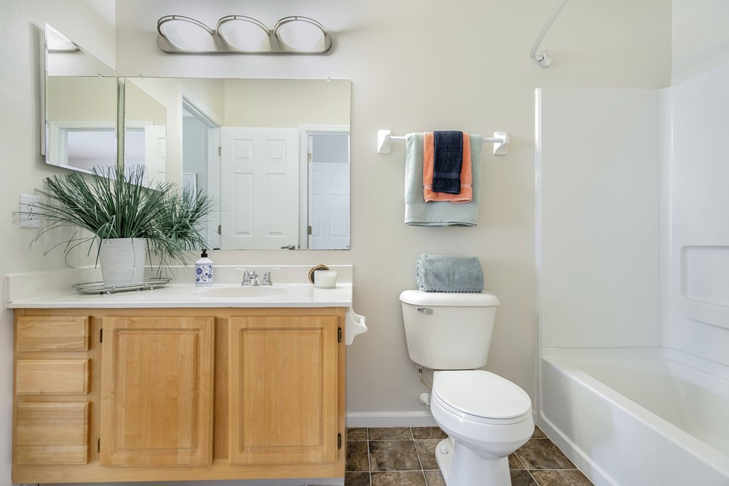 A white toilet sits next to a white sink in a bathroom.
