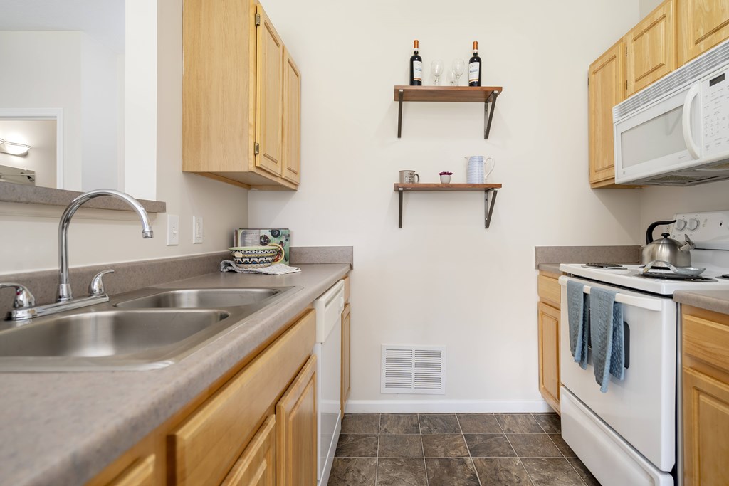 A kitchen with a white oven and a white microwave.